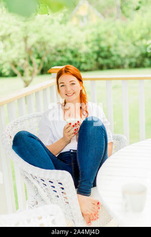 Young woman resting on balcony Stock Photo