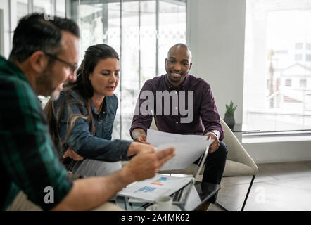 Casual meeting of diverse business team analyzing financial data Stock Photo