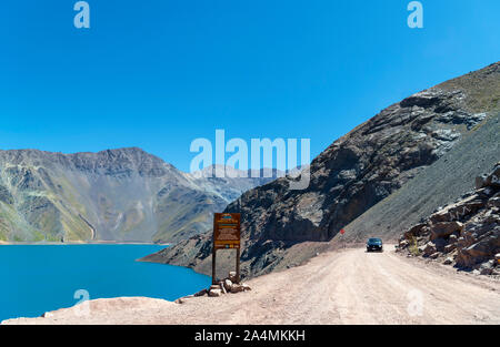 Chile, Andes Mountains. Car driving on the road alongside the Embalse el Yeso (El Yeso Dam), Andes Mountains, Santiago Metropolitan Region, Chile, Sou Stock Photo