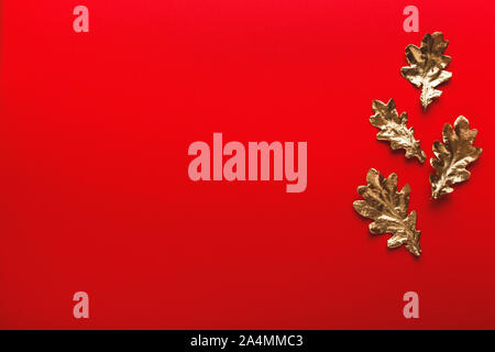 Autumn frame of golden oak leaves on a red background. Flat lay, copy space, trendy holiday concept Stock Photo