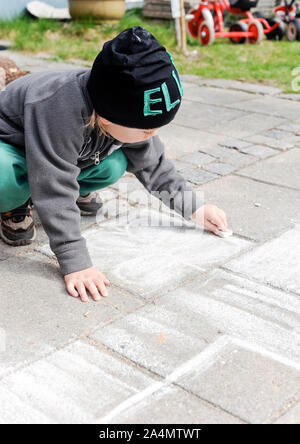 Boy Drawing On Sidewalk With Chalk Stock Photo - Alamy