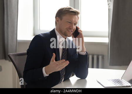 Smiling confident businessman talking on phone, making business call Stock Photo