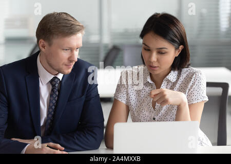 Asian businesswoman and Caucasian businessman working discussing project Stock Photo