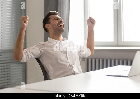 Excited businessman celebrating business success achievement, shouting Stock Photo