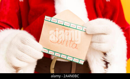 Santa Claus holding wish letter with text in hands Stock Photo
