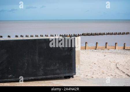 Looking onto the beach with a view of sea wall gate protection Stock Photo