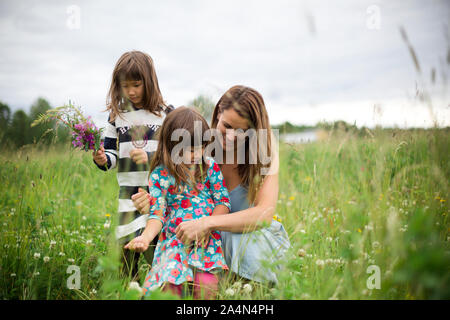 Mother with daughters on meadow Stock Photo