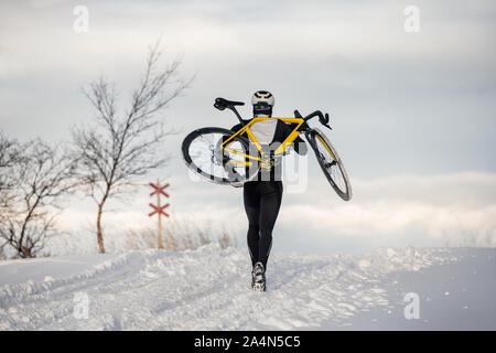 Man carrying bicycle at winter Stock Photo