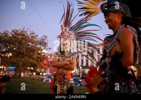 Mexica (Aztec) dancers gather at the Monroe County Courthouse after performing during Indigenous Peoples Day in Bloomington, Monday, October 14, 2019. A resolution passed by the Bloomington City Council officially puts Indigenous Peoples Day on the calendar as a holiday every second Monday of October. Stock Photo