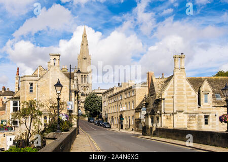 View along a street lined with old limestone buildings to St Mary's church from bridge over River Welland. Stamford, Lincolnshire, England, UK Stock Photo