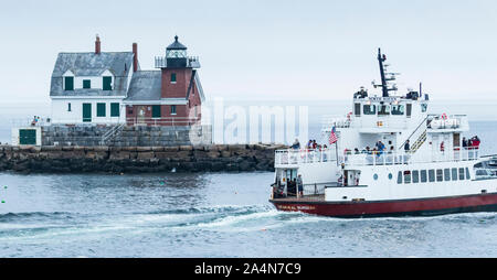 Rockland, Maine, USA - 5 August 2017: Rockland Breakwater Lighthouse in Rockland Maine with the North Haven Ferry ship passing it heading out to sea. Stock Photo