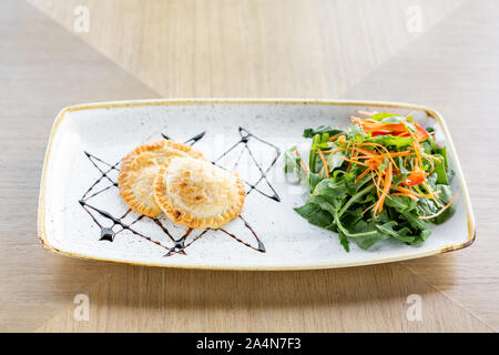 Latin American fried empanadas with Vegetable salad with arugula. Decorated with balsamic sauce. Menu restaurant