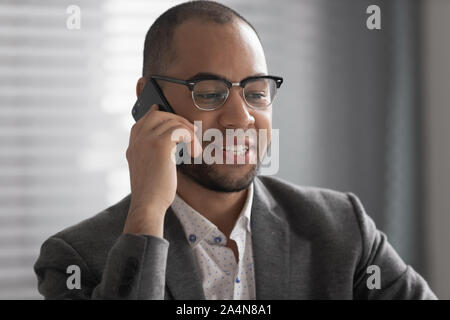Smiling African American businessman talking on phone close up Stock Photo