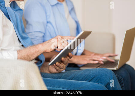 Modern mature couple using various gadgets, closeup Stock Photo