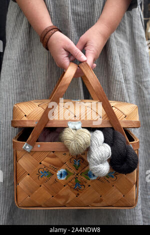 Woman holding basket with wool Stock Photo