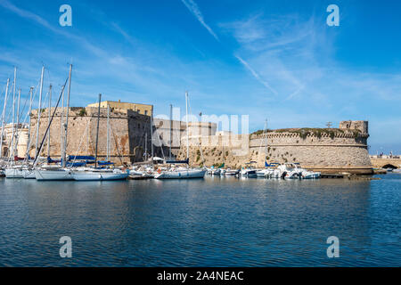 View across harbour to yachts moored next to Angevine-Aragonese Castle in Gallipoli old town, Apulia (Puglia) in Southern Italy Stock Photo