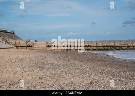 A view looking up Hornsea beach showing the split levels of sand coastal protection has been used with wooden groynes to help prevent longshore drift. Stock Photo