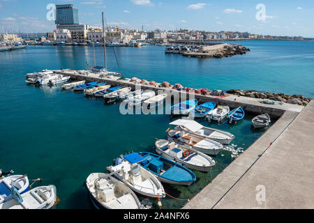 Boats moored in harbour next to old city wall in Gallipoli old town, Apulia (Puglia) in Southern Italy Stock Photo