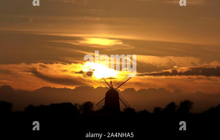 The sun sets behind the Great Haseley windmill in Oxfordshire. Stock Photo