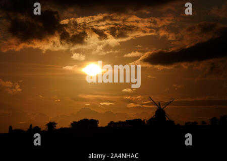 The sun sets behind the Great Haseley windmill in Oxfordshire. Stock Photo