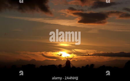 The sun sets behind the Great Haseley windmill in Oxfordshire. Stock Photo
