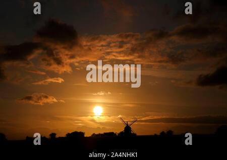 The sun sets behind the Great Haseley windmill in Oxfordshire. Stock Photo