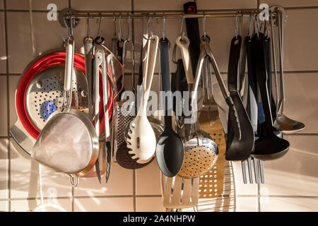 Various kitchen utensils, ladles, spoons, sieves, pliers, in a private kitchen, Stock Photo