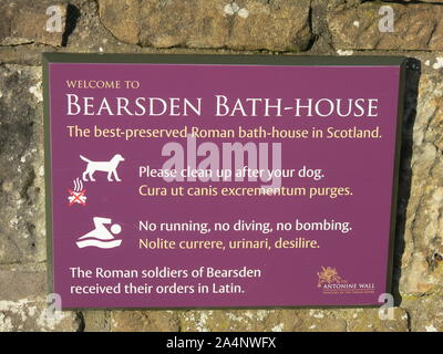 Information sign for tourists at the Roman bath-house heritage site in Bearsden; Latin orders for the soldiers to clean up after dogs & no running. Stock Photo