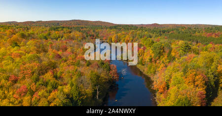 Fall color is more saturated at sunset over the Oswegatche River Adirondack Park Mountains New York Stock Photo