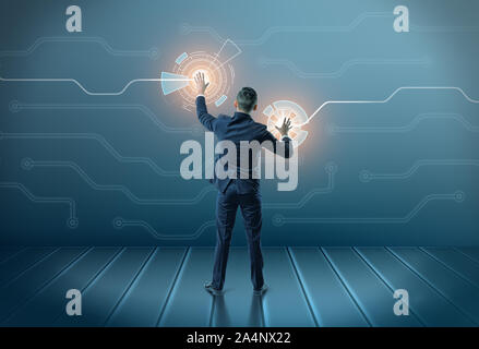 Back view of a businessman touching icons on digital screen with both hands Stock Photo