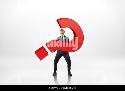 Full portrait of a businessman holding big red 3d question mark isolated on white background Stock Photo
