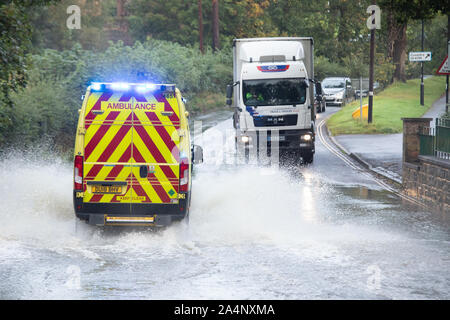 An Ambulance make it's way through the flooded ford in Castle Street Kenilworth after recent heavy rain and storms Stock Photo