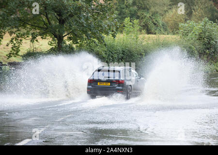 A car makes it's way through the flooded ford in Castle Street Kenilworth after recent heavy rain and storms Stock Photo