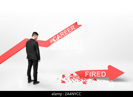 Businessman looking at broken arrow with 'fired' word Stock Photo