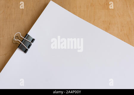 Blank sheet of paper on wooden dest. Office workplace. Mockup for design. Stock Photo
