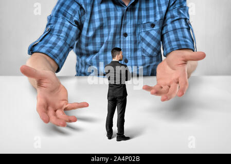 Businessman stands in front of cropped portrait big man sitting Stock Photo