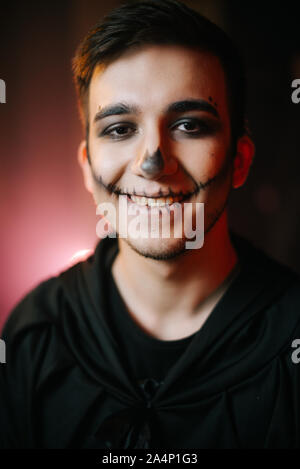 Young man with Halloween make-up smiling at the camera Stock Photo