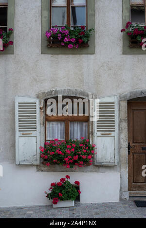 Windows with shutters and flowers in Ancient town of Gruyère, Switzerland Stock Photo