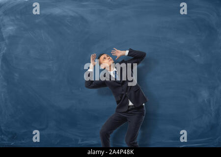 Young businessman in defensive pose afraid of something isolated on ...