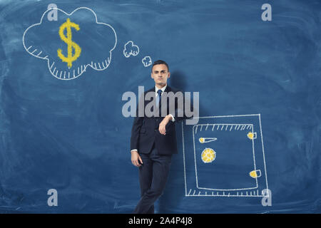 Businessman leaning on drawn safety box and thinking about money. Stock Photo