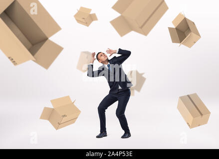 Frightened businessman and empty boxes falling on him Stock Photo