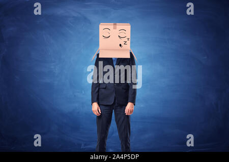 Businessman is wearing cardboard box on head with sleepy face Stock Photo