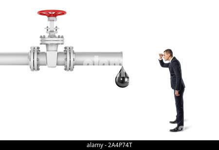 Businessman on white background looking at pipe with red valve that's leaking one big oil drop Stock Photo