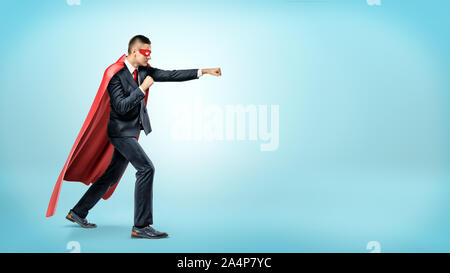 A Businessman In A Flowing Red Superhero Cape And A Mask Throwing Punches At An Invisible Enemy On White Background Stock Photo Alamy