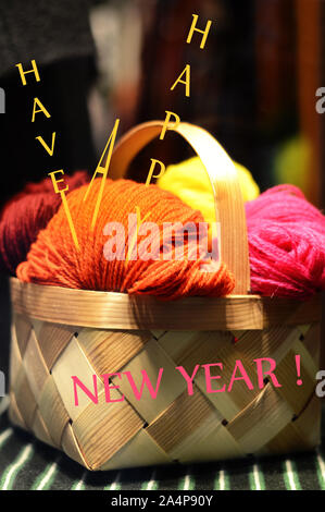 concept for new year and christmas celebration - words 'have a happy new year' written on the background of a colorful yarn balls in a wooden basket Stock Photo