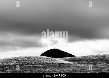 Black mountain with crucifix on the top between hills - Italy landscape Stock Photo