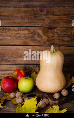 Pumpkin, apples and walnuts on rustic wooden background with space for text. Thanksgiving and harvest Stock Photo