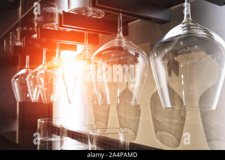 Group of empty wine glasses hanging from wooden beams. Stock Photo
