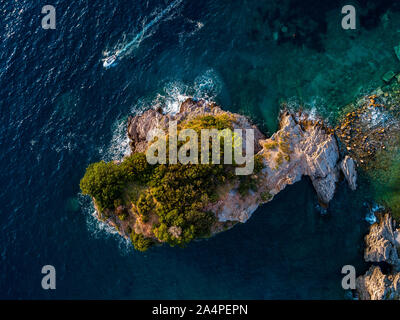 Aerial view of a speedboat hurtling near the island of Sveti Nikola, island of Budva, Montenegro. Jagged coasts with sheer cliffs and sea Stock Photo