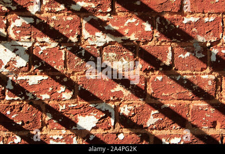Weathered brick wall and diagonal shadows Stock Photo